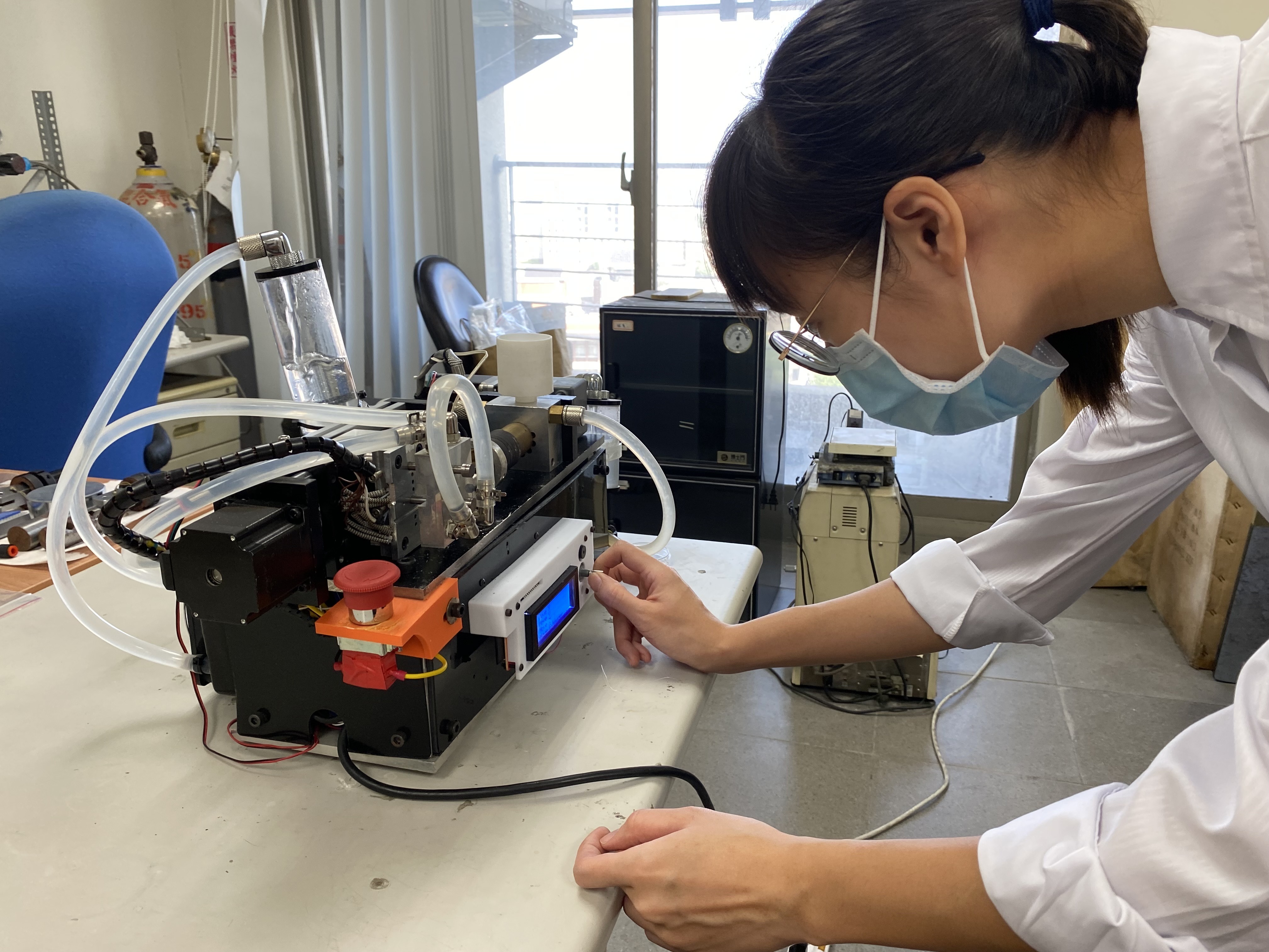 圖二：成大材料系特聘教授洪飛義團隊研發血管支架全球創新材料PLAM，圖為博士生黃嫈庭操作製作支架的精密微型射出機。