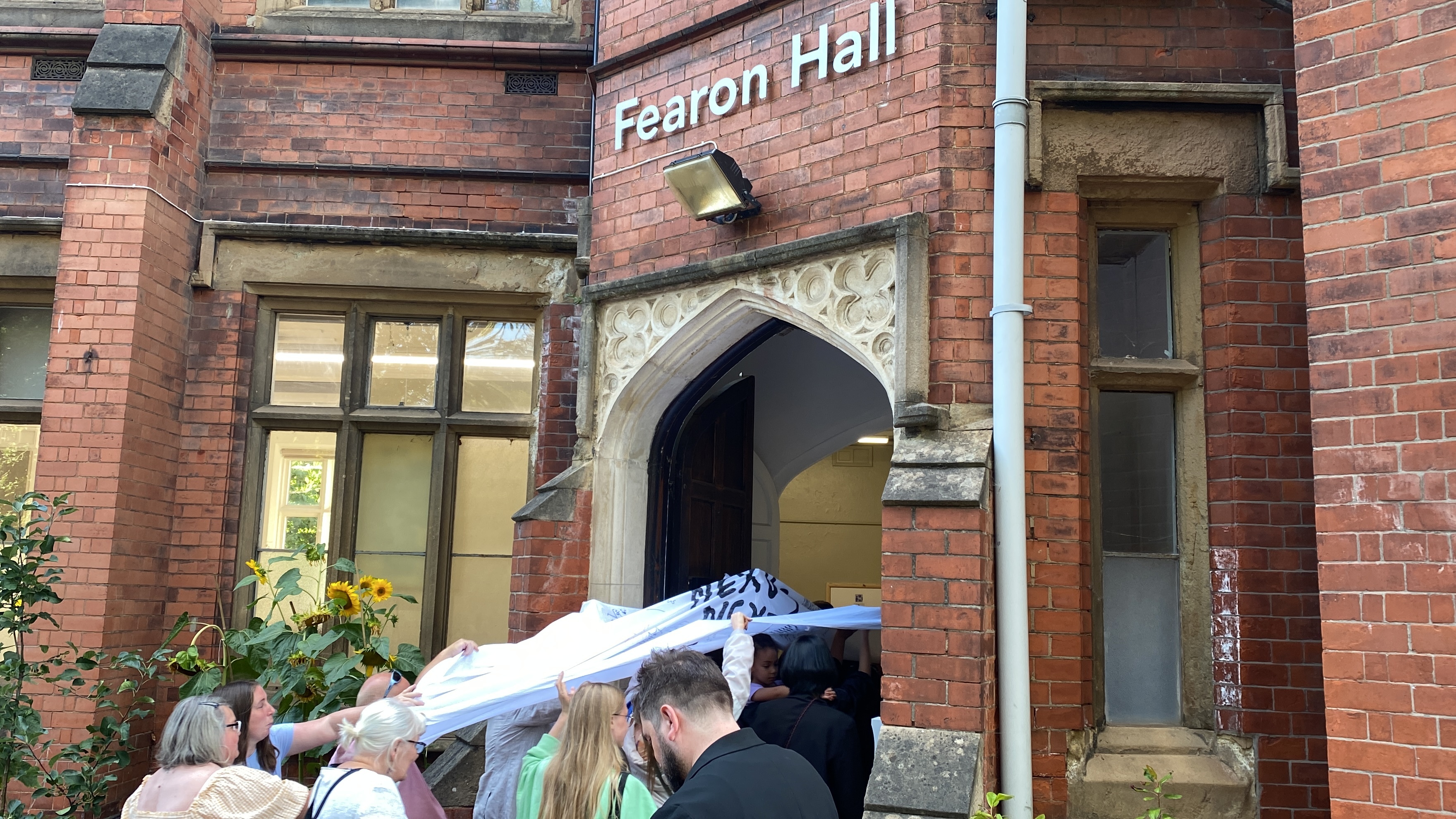 成果展現場，眾人撐起白色床單走進展場，象徵各種力量飛進Fearon Hall