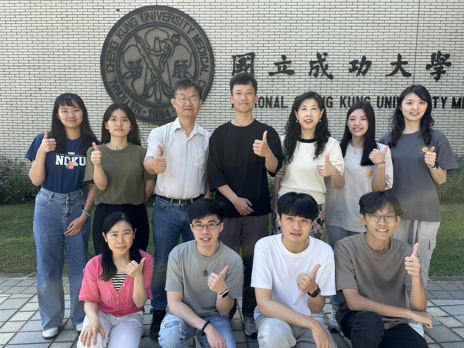 圖二:成大藥理學研究所所長王憶卿講座教授(後排右3)與生物科技與產業科學系洪建中特聘教授(後排左3)團隊