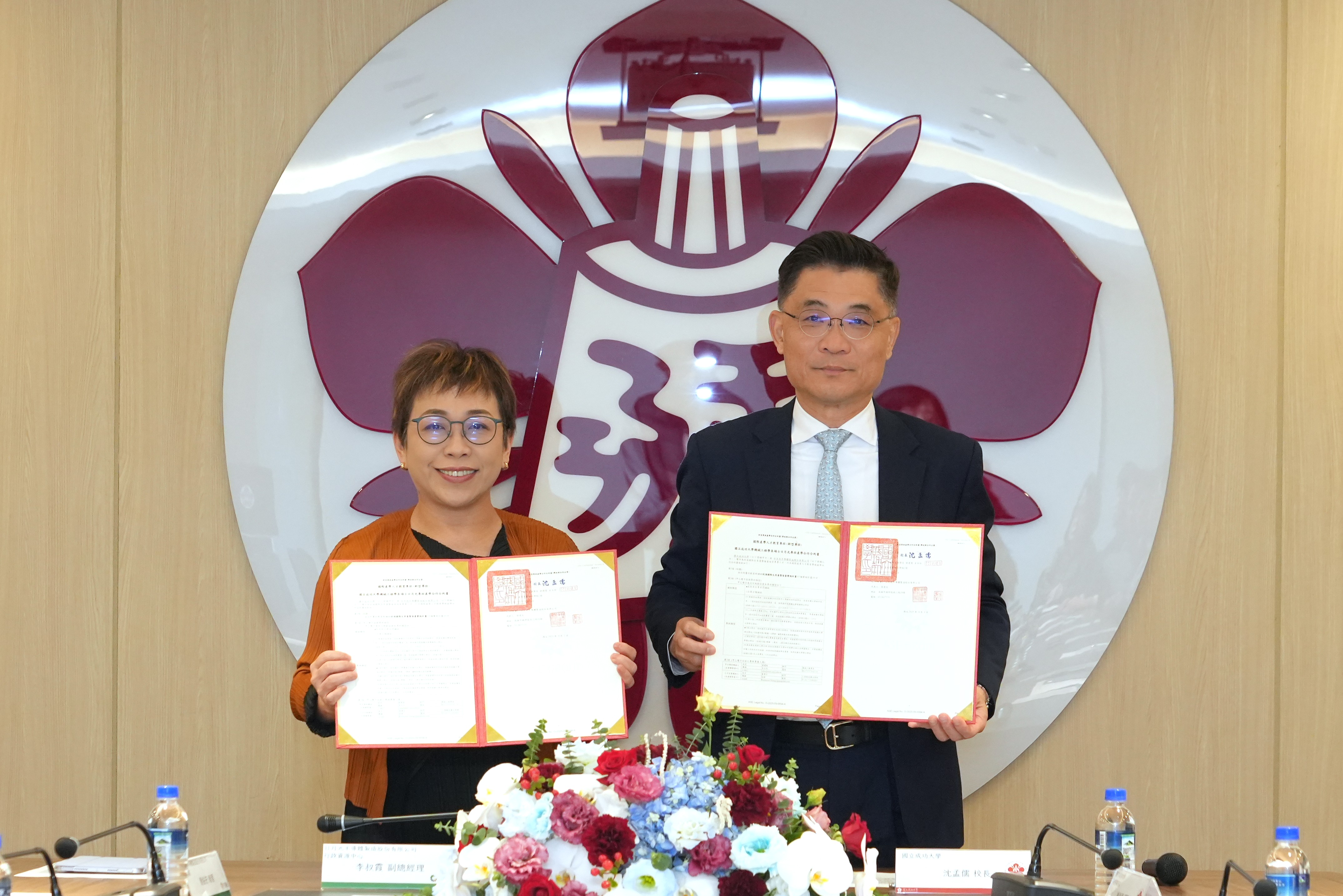 成大沈孟儒校長與日月光李叔霞副總一同舉起新型專班合作合約
