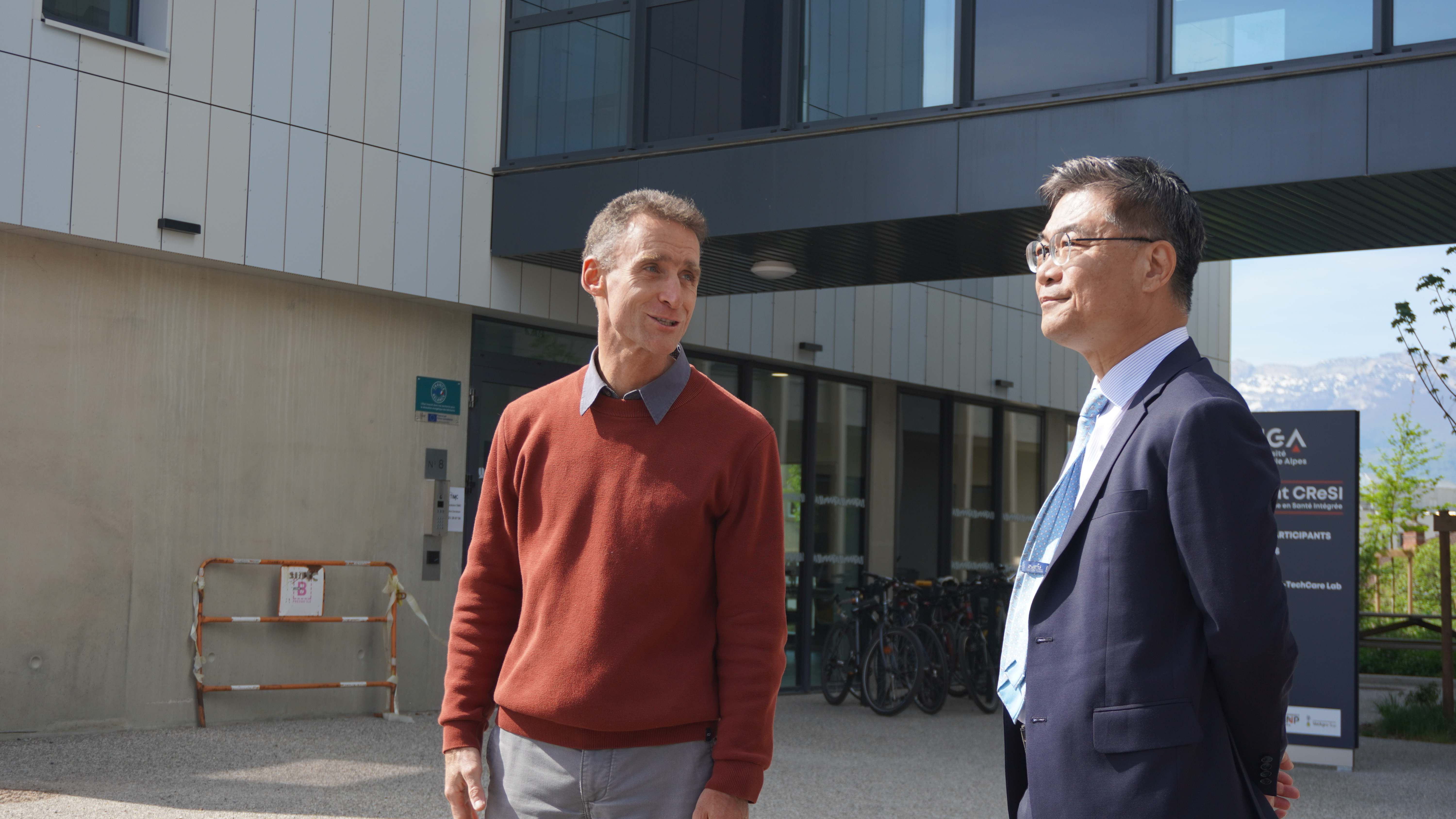 HP2 實驗室主任 Samuel Vergès 博士（左）向沈孟儒校長介紹整合健康研究中心規劃與環境。